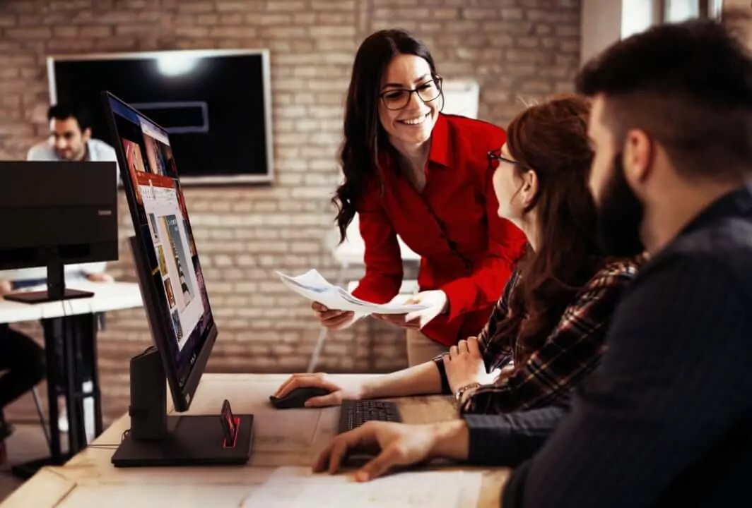 A group of people sitting at a computer