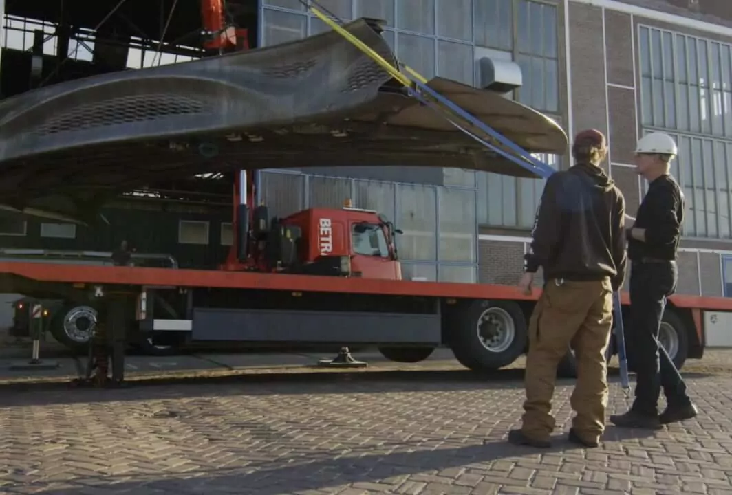 Builders are loading cargo with a crane